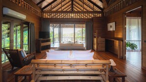 Un dormitorio amplio con una cama grande, paredes de madera y techo inclinado.