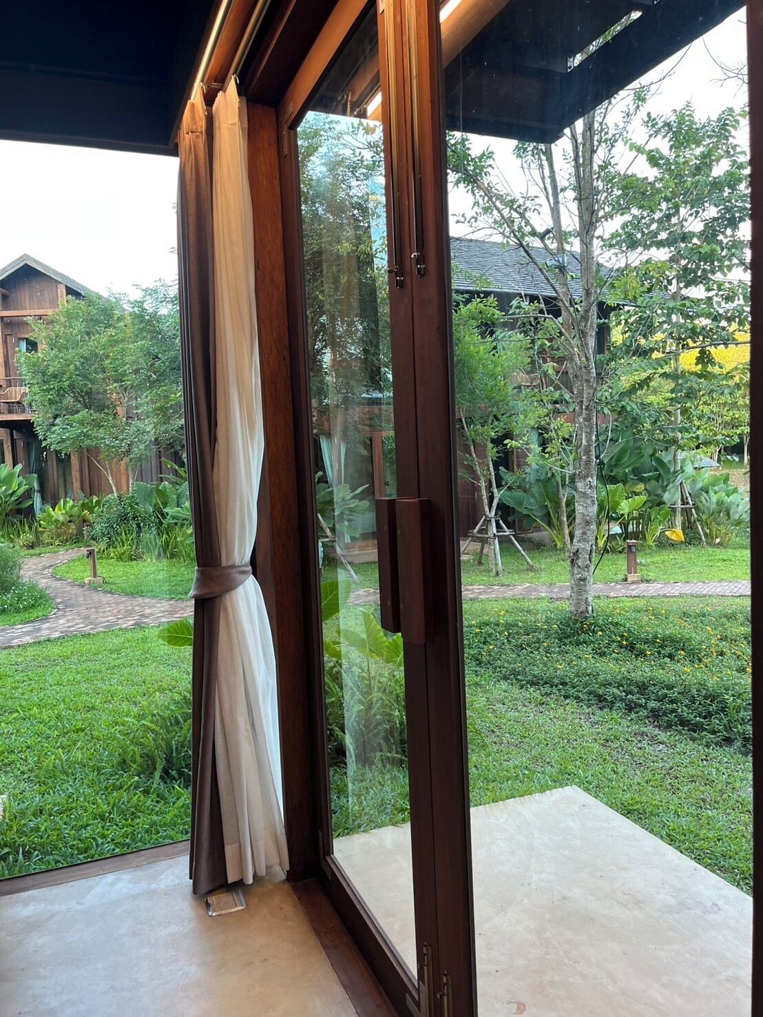 A room with a large sliding glass door leading to a garden.