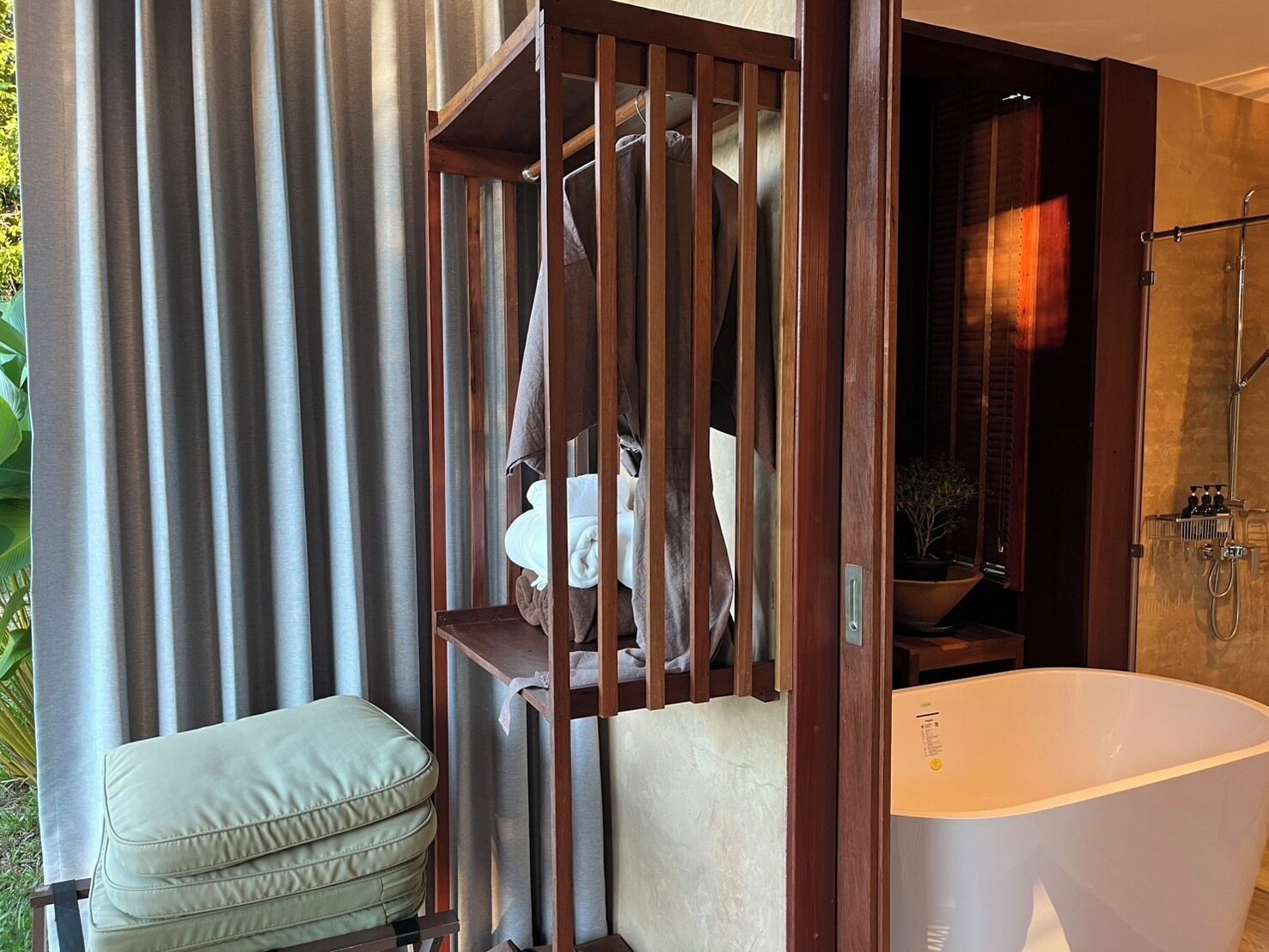 A bathroom with a freestanding bathtub, wooden paneling, and a towel rack.