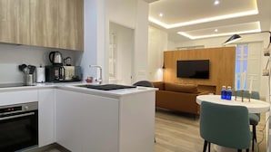 A modern kitchen with a built-in oven, a coffee maker, and a sink.
