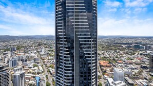 A tall, modern hotel with a prominent name at the top, surrounded by a cityscape.