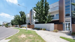 Un immeuble résidentiel moderne doté d’une allée incurvée, d’un trottoir et d’une rue.