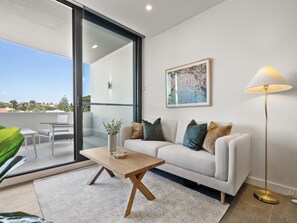 A modern living room with a sofa, coffee table, and floor lamp.