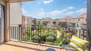 A balcony with a view of a residential complex, including a garden area and multiple buildings. - Sleek 2-bed Apartment in Vibrant Kingston (Canberra)