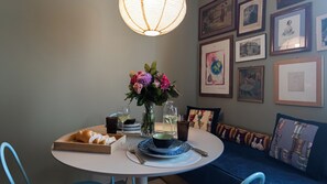 A dining table with a vase of flowers, a plate of bread, and a glass of wine. - Italianway Easy - Sarpi 58 (Milan)