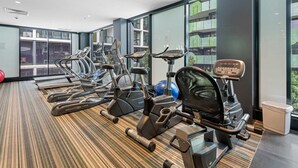 A gym with treadmills, stationary bikes, and a rowing machine. - Eclectic 1-bed Apartment With Pool and Gym (Melbourne)