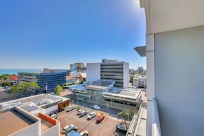 A modern building with a parking lot and a view of the sea. - Stylish 1-bed Darwin City Stay With Balcony Views (Darwin)