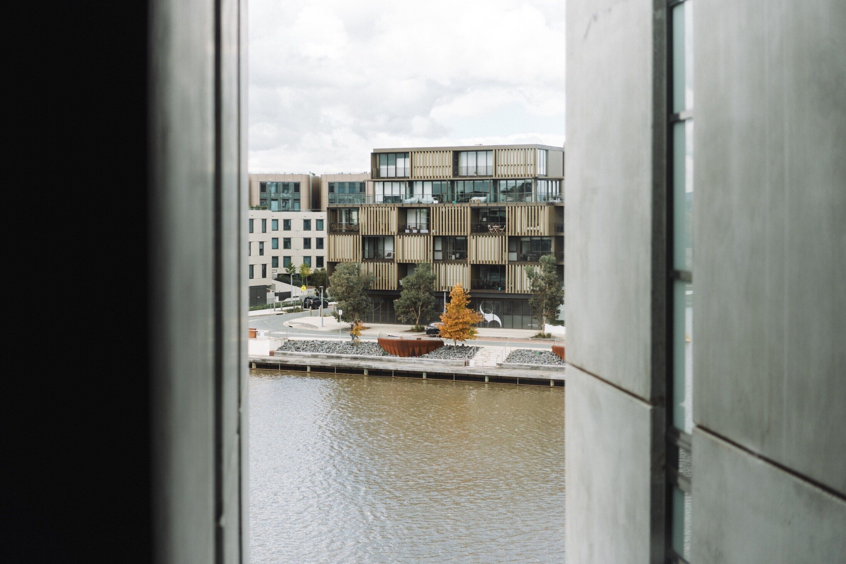 Vista di un edificio moderno con specchio d'acqua in primo piano.