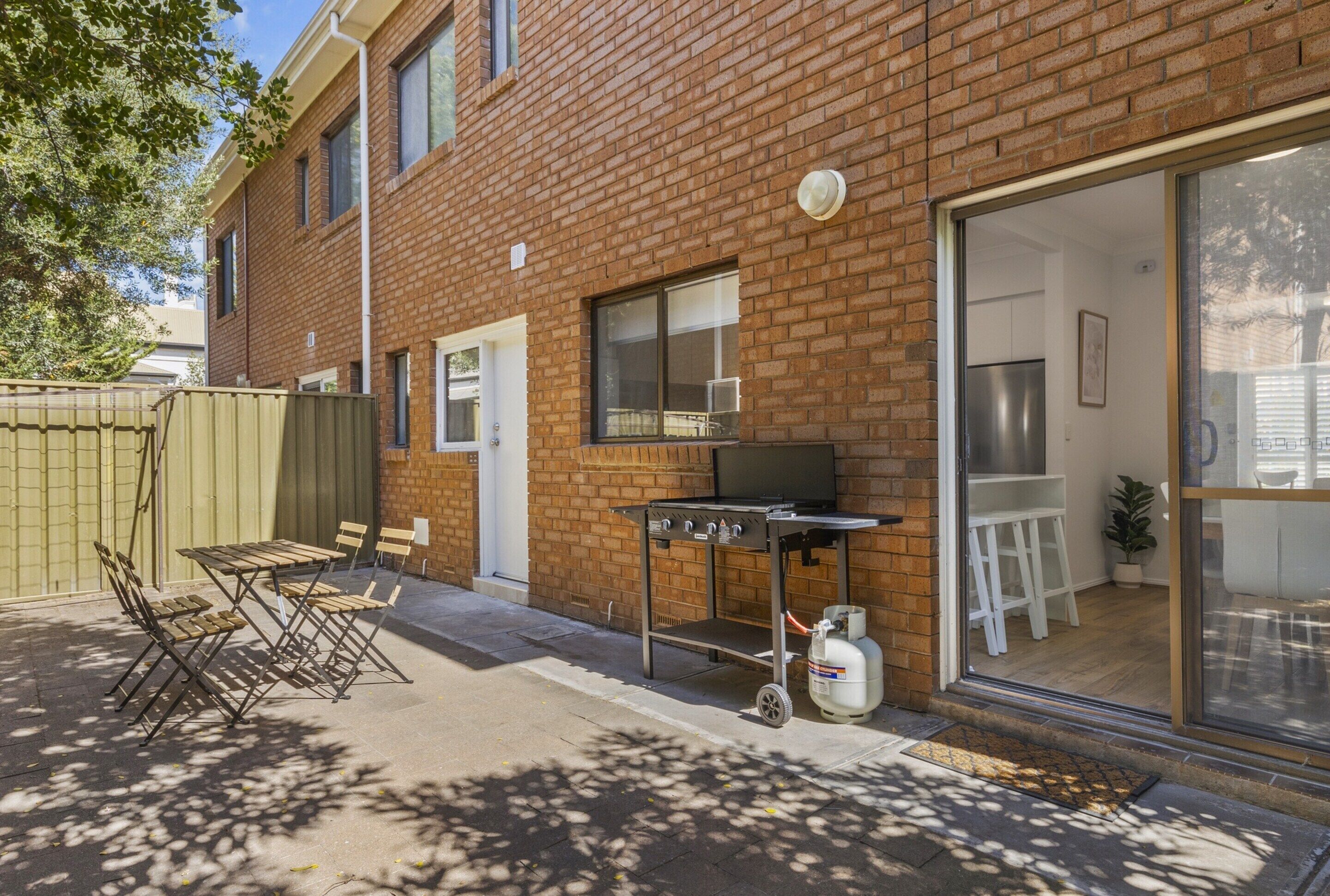 A brick building with a sliding glass door leading to a kitchen area.