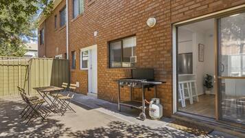 A brick building with a sliding glass door leading to a kitchen area.