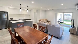 Una cocina moderna con comedor, sofá y televisión.
