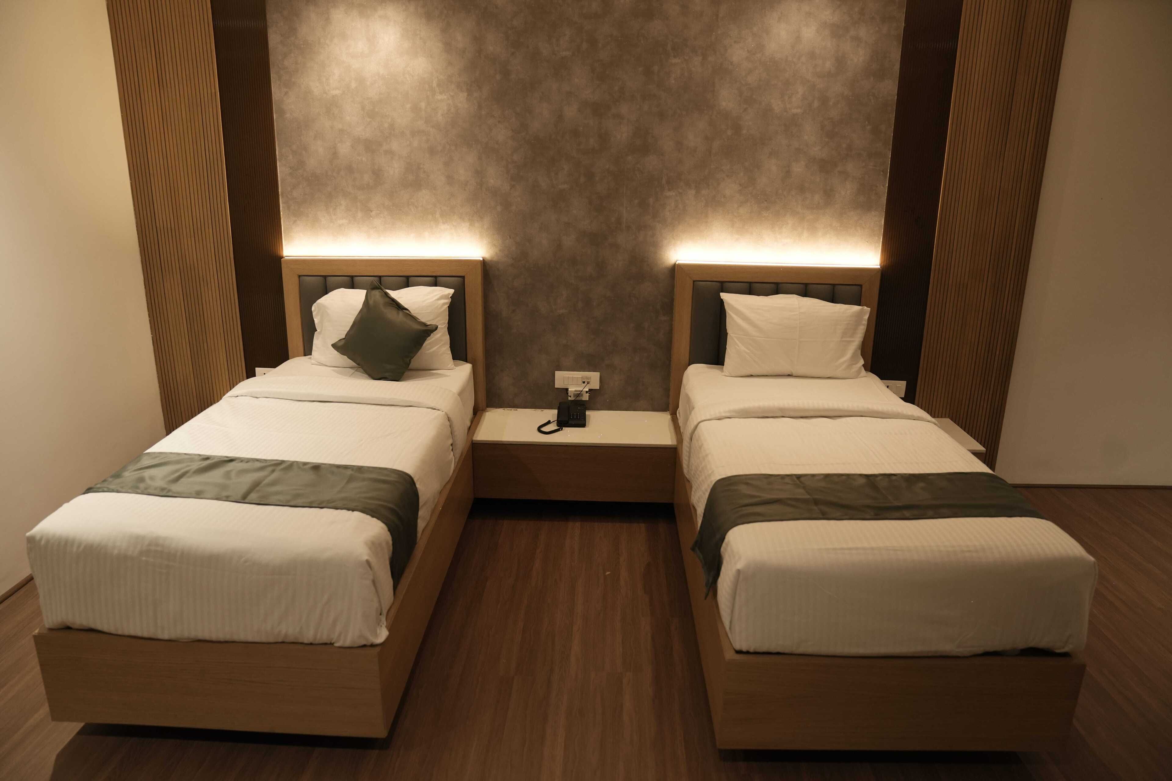 Ein Doppelzimmer mit zwei Betten, jeweils mit Kissen und Decke.