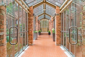 A corridor with brick walls, large windows, and metal railings. - Cosy and Central City Studio Near Attractions (Melbourne)