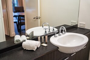 A bathroom with two sinks, a mirror, and towels. - Chic 1-bed in East Melbourne With Gym & Pool (Melbourne)