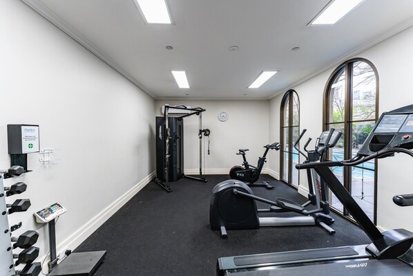 A gym with exercise equipment, a treadmill, and a stationary bike. - Chic 1-bed in East Melbourne With Gym & Pool (Melbourne)