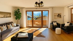 Uma sala de estar moderna com sofá, banqueta e poltronas, uma janela grande com vista para as montanhas e um lustre.