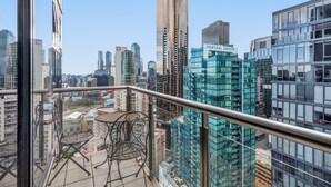 A balcony with a view of a cityscape, including a building labeled "CENTRAL EQUITY". - Luxe 2-bed Apartment With River Views Near Casino (Melbourne)