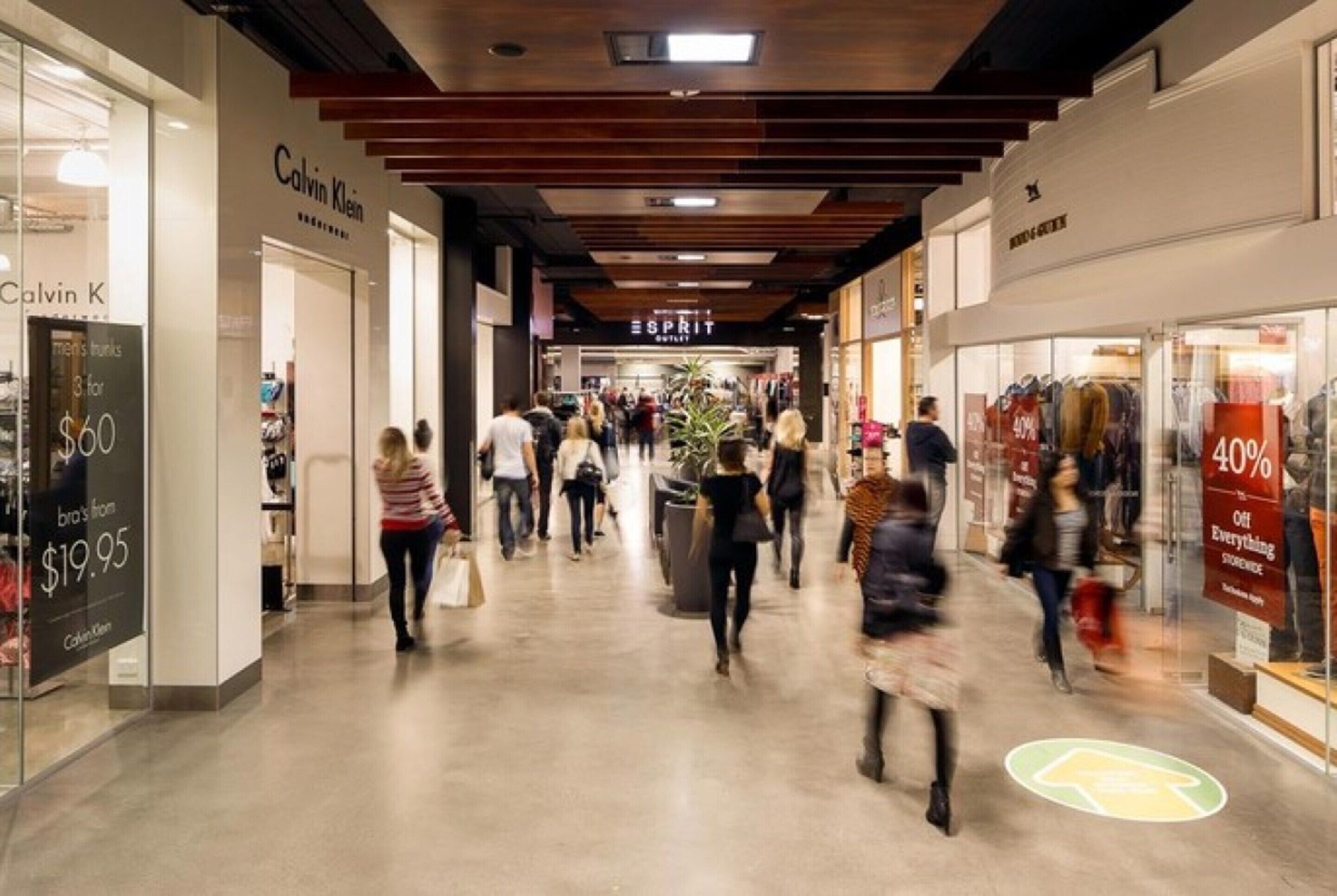 A shopping mall corridor with stores like Calvin Klein and Esprit.