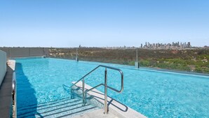 Piscina no terraço com vista para o horizonte da cidade.
