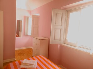 A bedroom with a bed, a dresser, a mirror, and a window. - Casa do Mestre By Gt House (Évora)