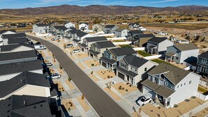 A residential area with houses, a main road, and distant mountains. - Park City Redbud Hideaway | Modern 6BR Mountain Retreat w/ Hot Tub & Views (Park City)