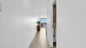 Un pasillo con vista a un balcón y un comedor.
