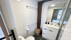 Une salle de bain moderne équipée de toilettes, d’un bidet et d’un meuble-lavabo avec un miroir.