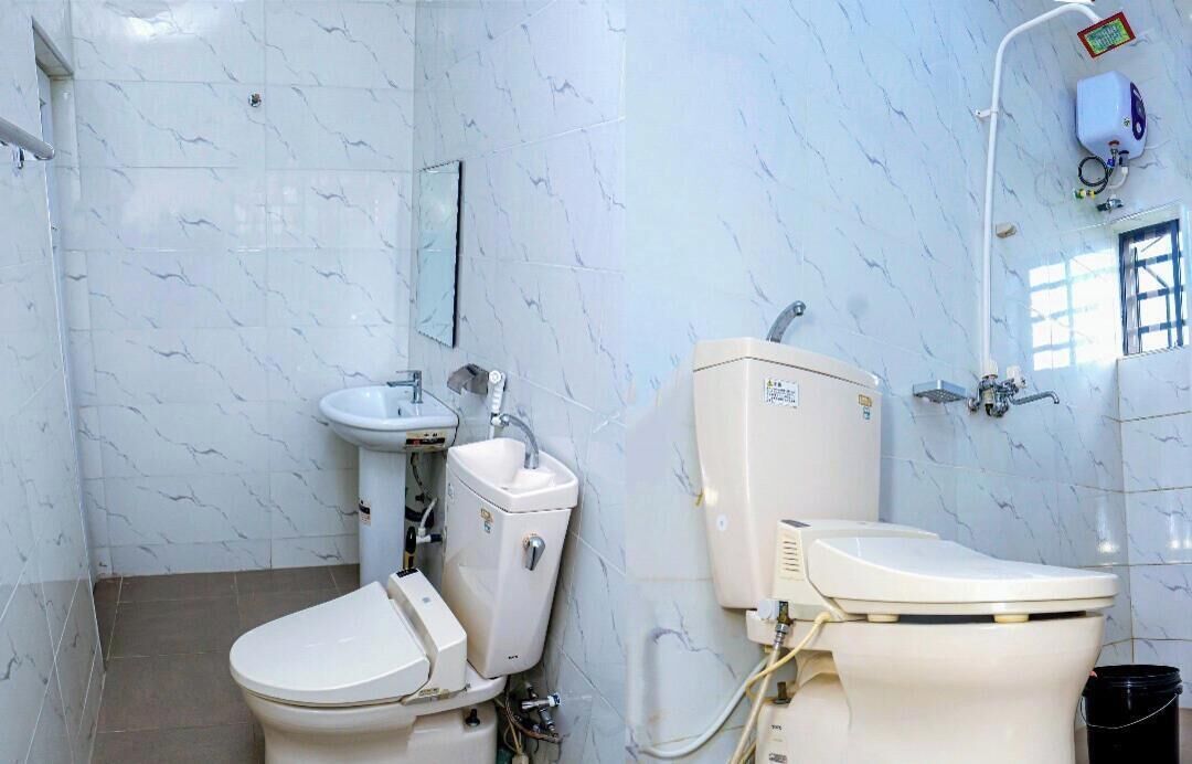 A bathroom with a toilet, sink, and a water heater.