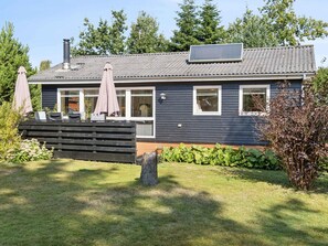 A modern house with a covered patio, a chimney, and a solar panel. - 4 Star Holiday Home in Hals (Hals)