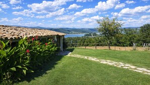 A villa with a tiled roof, a stone pathway, and a view of a lake and mountains. - SCAPPO IN UMBRIA, Casale al Lago (Baschi)