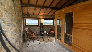 A stone-floored room with wooden beams, two large windows, and a glass door leading to a balcony. - SCAPPO IN UMBRIA, Casale al Lago (Baschi)