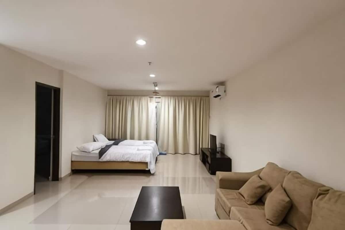 Une chambre dâhĂŽtel moderne Ă©quipĂ©e dâun lit, dâun canapĂ©, dâune table basse et dâun tĂ©lĂ©viseur.