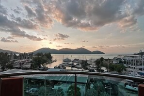 Ein Yachthafen mit Booten, wolkenlosem Himmel und fernen Bergen.