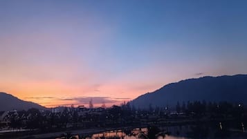 A sunset over a body of water with a bridge and buildings in the background.