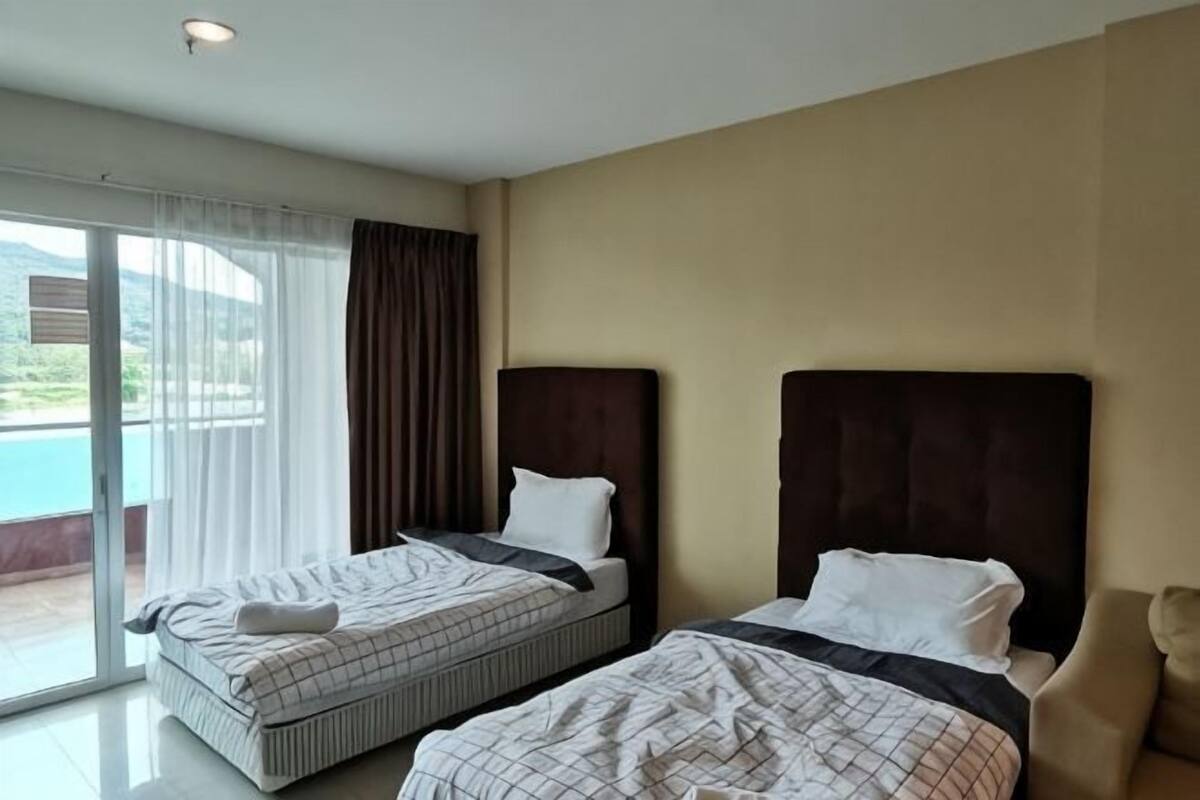 A hotel room with two beds, a large window with curtains, and a view of the outdoors.