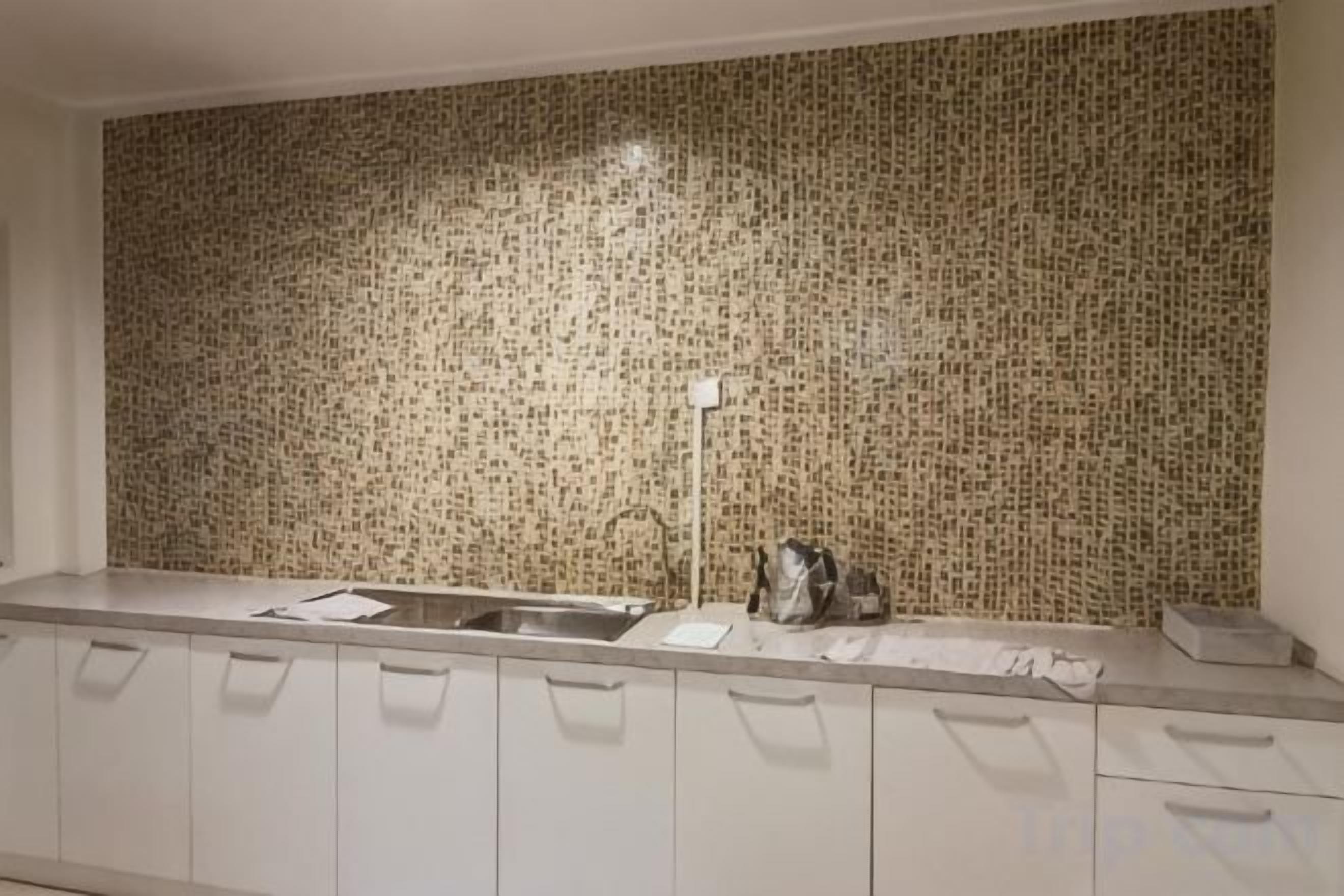 A kitchen with a patterned backsplash, a sink, and cabinets.