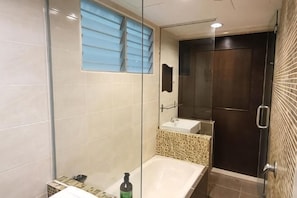 Une salle de bain moderne avec une douche Ă parois de verre, un meuble-lavabo et un grand miroir.