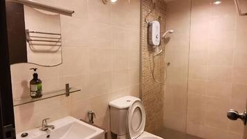 A bathroom with a sink, toilet, and shower.