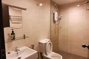 A bathroom with a sink, toilet, and shower. - Spacious & Homey Apartment at Marina Island by JoMy Homestay (Manjung)