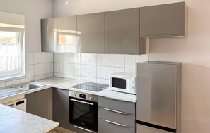 Réfrigérateur, un four, surface de cuisson, lave-vaisselle