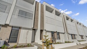 A modern building with a series of large windows and a flat roof. - Oceanview Luxury With Dedicated Workspace (Adelaide)