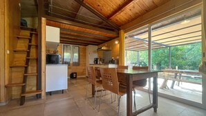 Un intérieur en bois comprenant une cuisine, un coin repas et de grandes fenêtres.