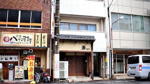 A street view with a restaurant, a closed shop, and a parked van.