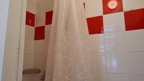 A bathroom with a shower, a white sink, and red and white tiled walls. - Cozy 1BR Apt Long Stay for 3 Guests (Vienna)