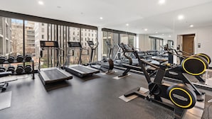 Een moderne sportschool met loopbanden, elliptische trainers en gewichten.