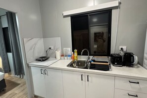 Una cocina moderna con horno empotrado, un lavamanos y una ventana sobre la encimera.
