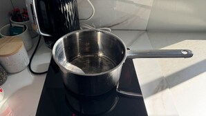 En bærbar induktionskogeplade med en gryde på.