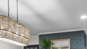 A dining area with a wooden table, black chairs, a hanging light fixture, a fireplace, and a brick wall. - Spacious|Close to DT|5 BDRM|4BA|PetsOK (Greenville)