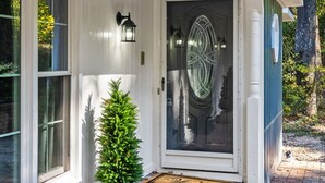A house with a white exterior, a glass door with a decorative design, a small potted plant, and a welcome mat. - Spacious|Close to DT|5 BDRM|4BA|PetsOK (Greenville)