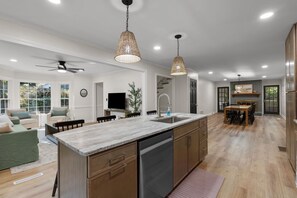 A modern kitchen with a large island, wooden cabinets, and pendant lighting. - Spacious|Close to DT|5 BDRM|4BA|PetsOK (Greenville)